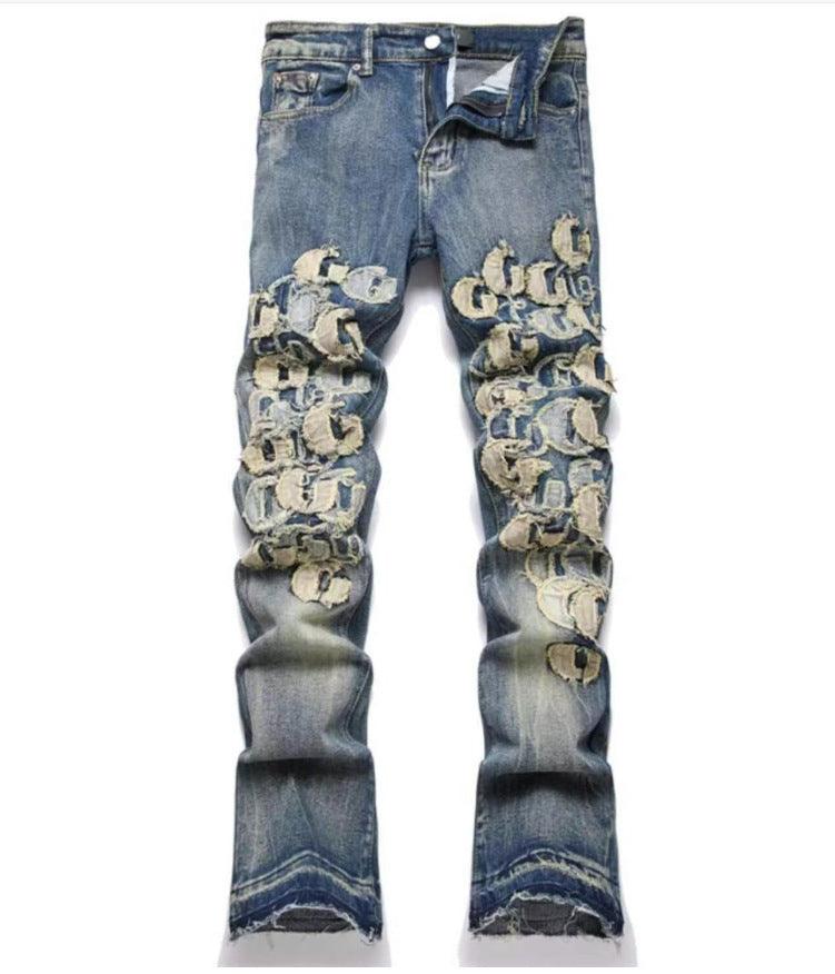 Medium blue jeans with all-over gold graphic print and distressed knee areas