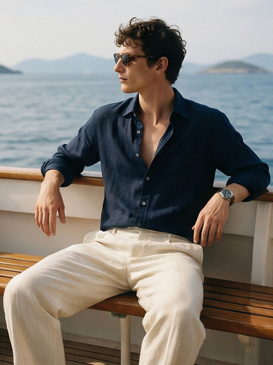 Navy linen long-sleeve button-up shirt with open collar, modeled from side.