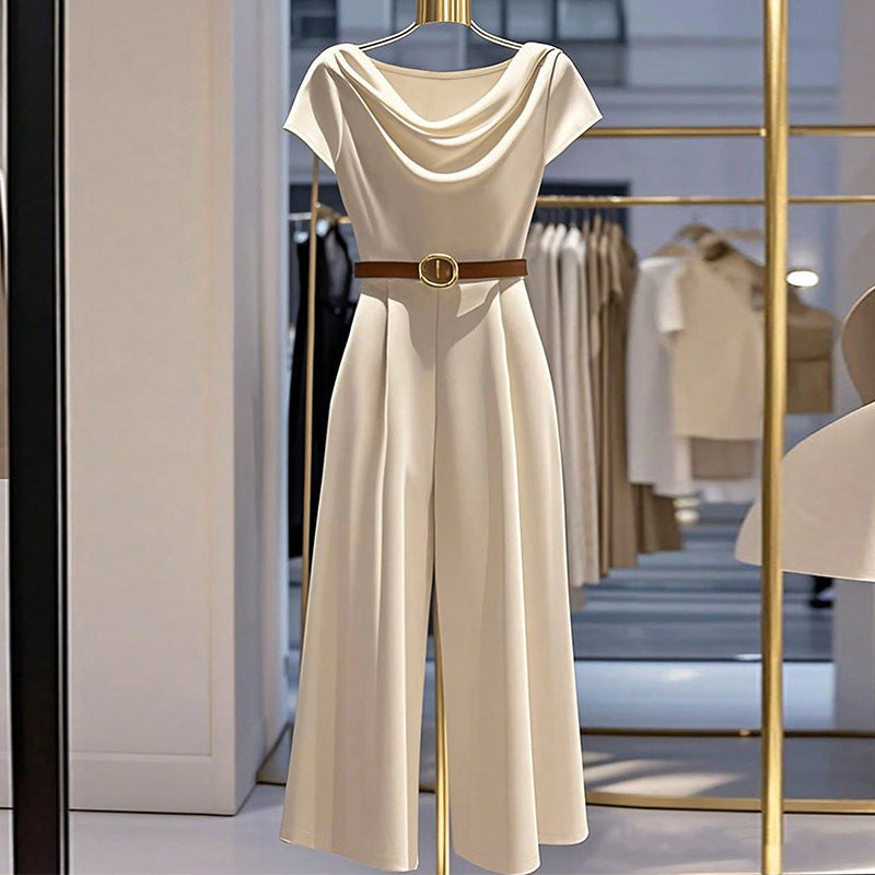 Apricot satin jumpsuit with draped cowl neckline and gold buckle waist belt