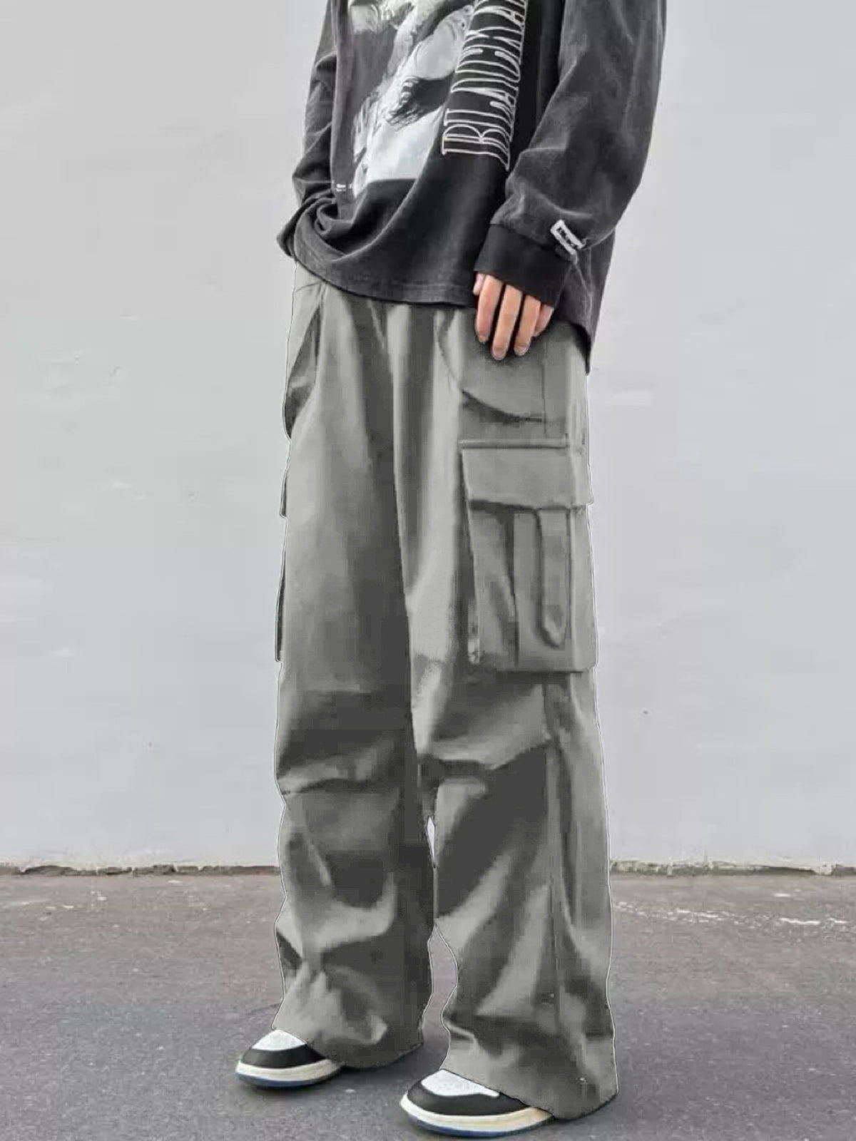 Dark gray wide-leg cargo trousers with flap side cargo pockets and loose straight legs