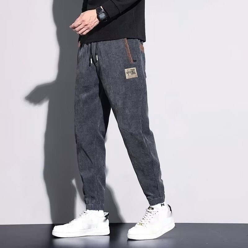 Dark gray corduroy velvet jogger-style pants with drawstring and elastic cuffed hem