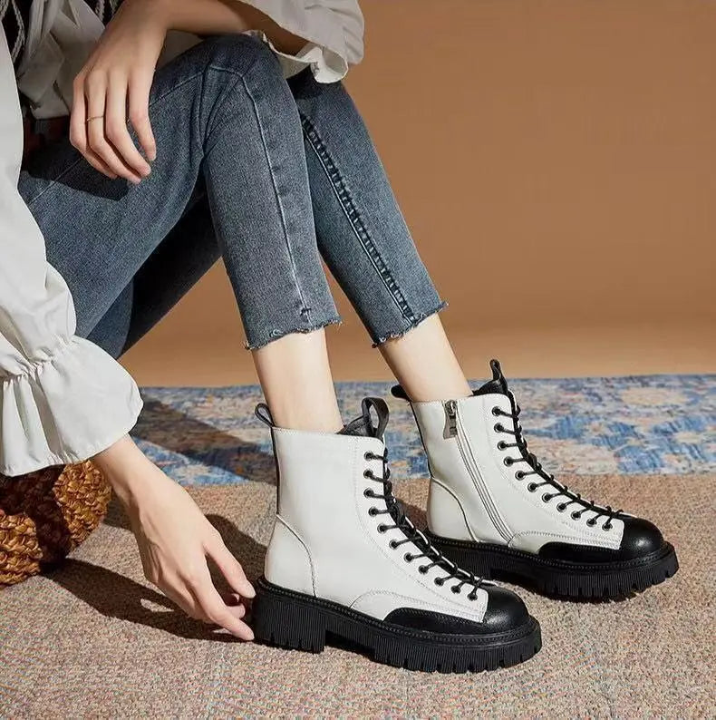 Black and white lace-up ankle boots with black soles and eyelet laces
