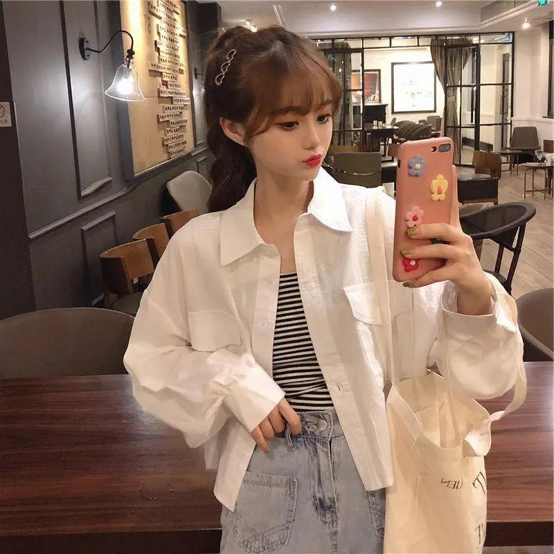 Loose white button-up long-sleeve shirt with chest pockets and point collar