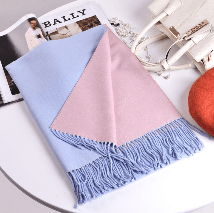 Warm cashmere scarf with light blue and blush pink panels and fringed edges.