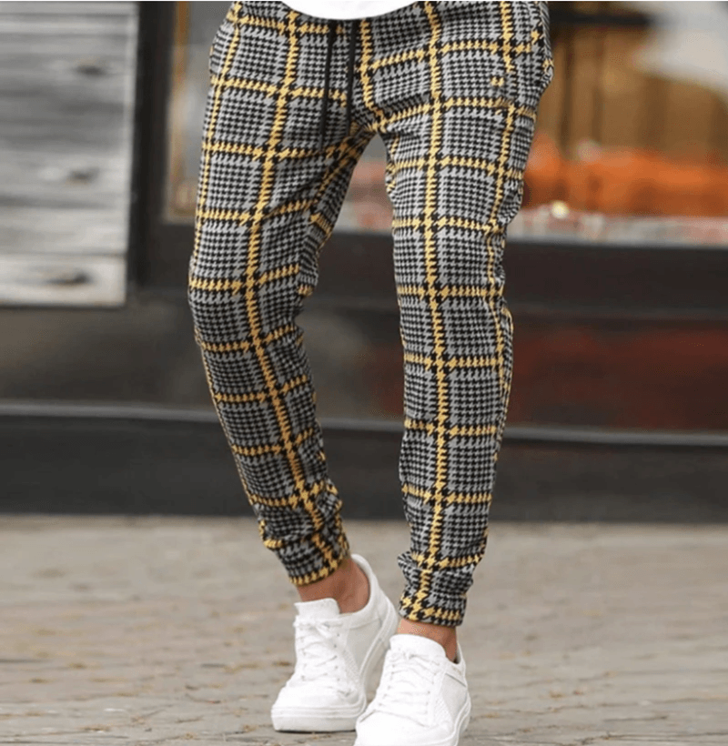 Men's black and yellow checkered jogger pants close-up, tapered legs and elastic cuffs
