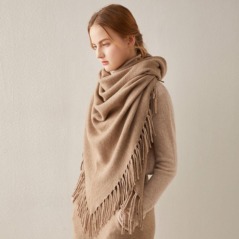 Fringed cashmere shawl in camel, draped over shoulders with long edge tassels