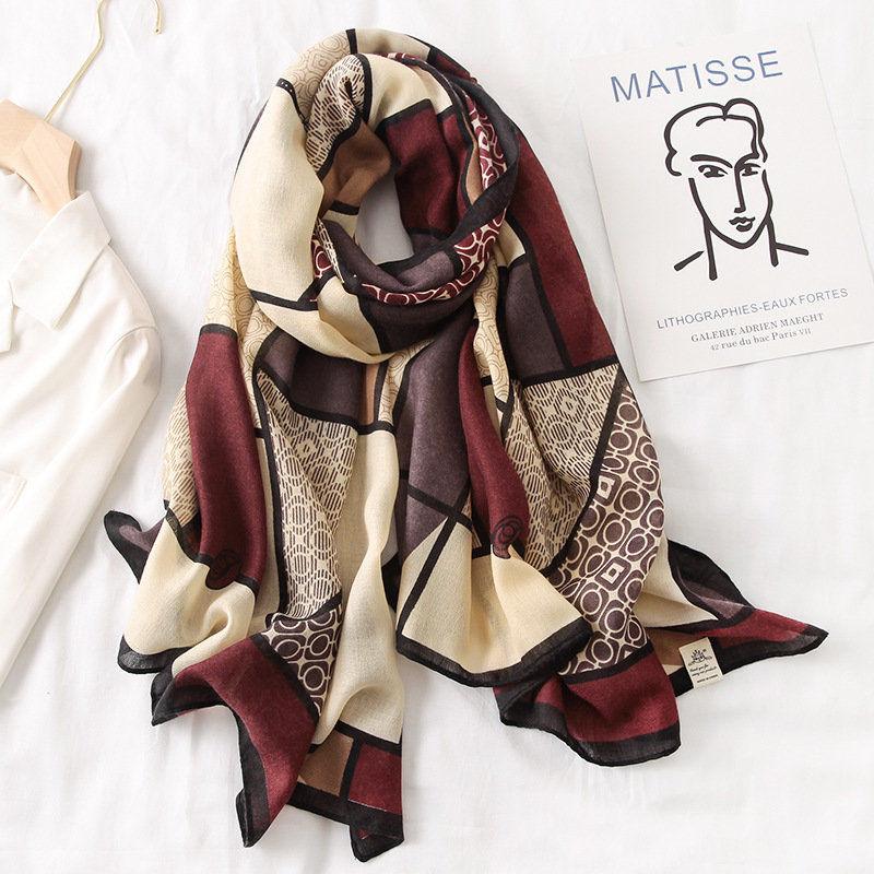 Multicolor silk scarf with cream, burgundy, and black abstract panels, folded.