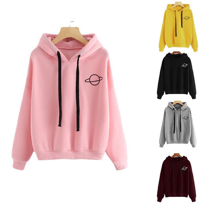 Pink pullover hoodie with hood, black drawstrings, front pocket, and small planet print