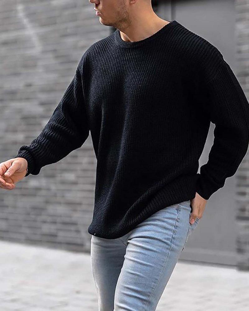 Black knit crewneck sweater with long sleeves, relaxed drape