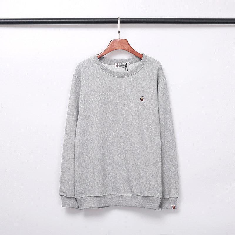 Grey round-neck sweater with small chest embroidery and ribbed cuffs.
