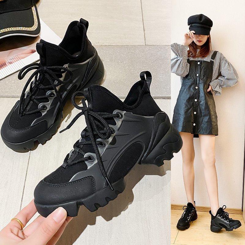 Black platform sneakers with chunky sole, lace-up closure, and high ankle support