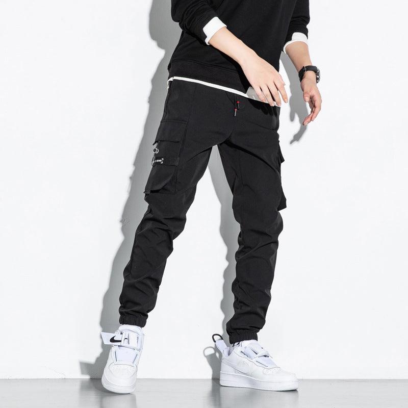 Black cargo trousers with drawstring cuffs and thigh utility pocket, side view