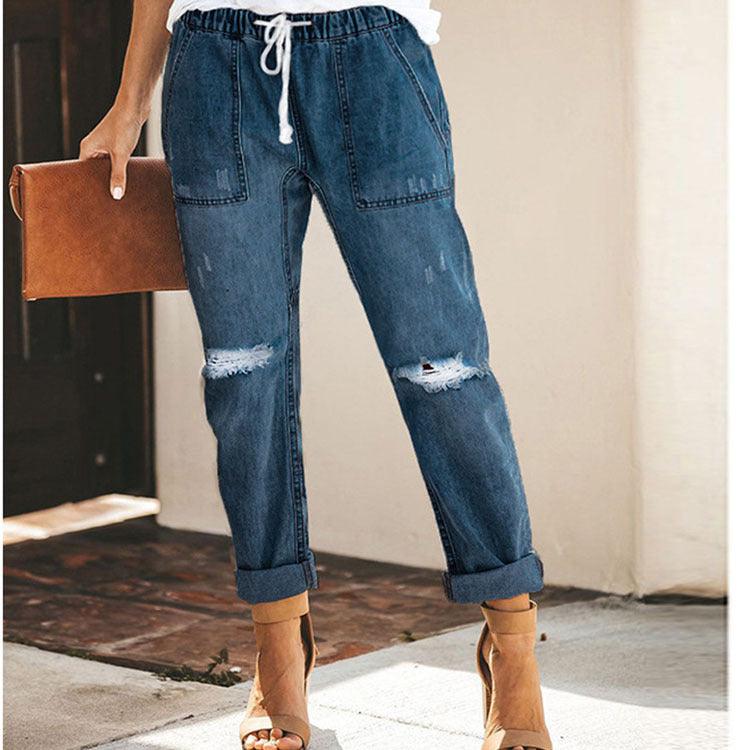 Dark blue ripped denim trousers with elastic drawstring waist, patch pockets, cuffed ankles
