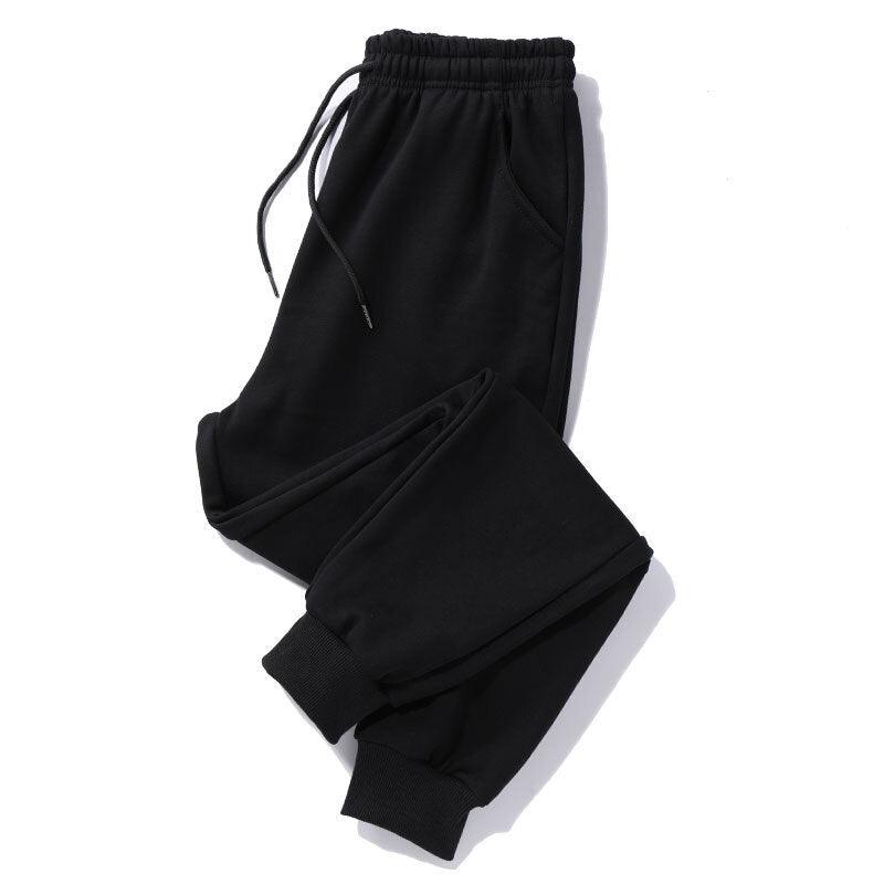 Black drawstring jogger trousers with elastic waistband and tapered legs, side pockets