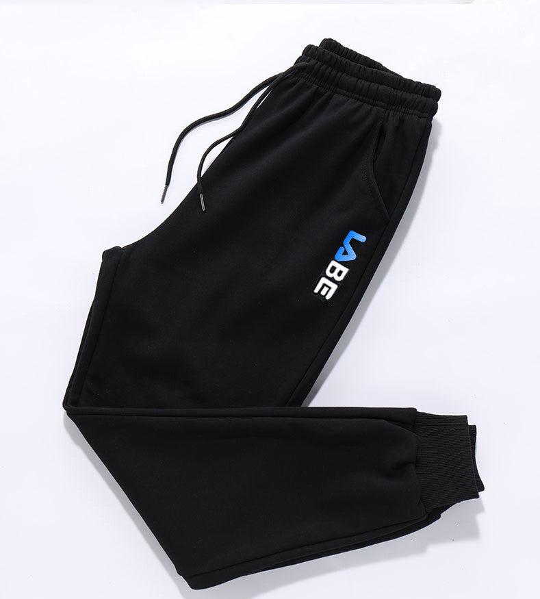 Black jogger trousers with drawstring waist, elastic cuffs, side pocket, and blue vertical logo