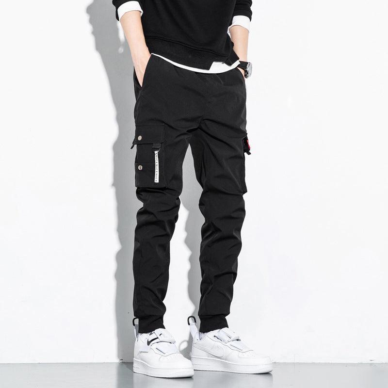 Black cotton cargo trousers with side utility pockets and drawstring waist