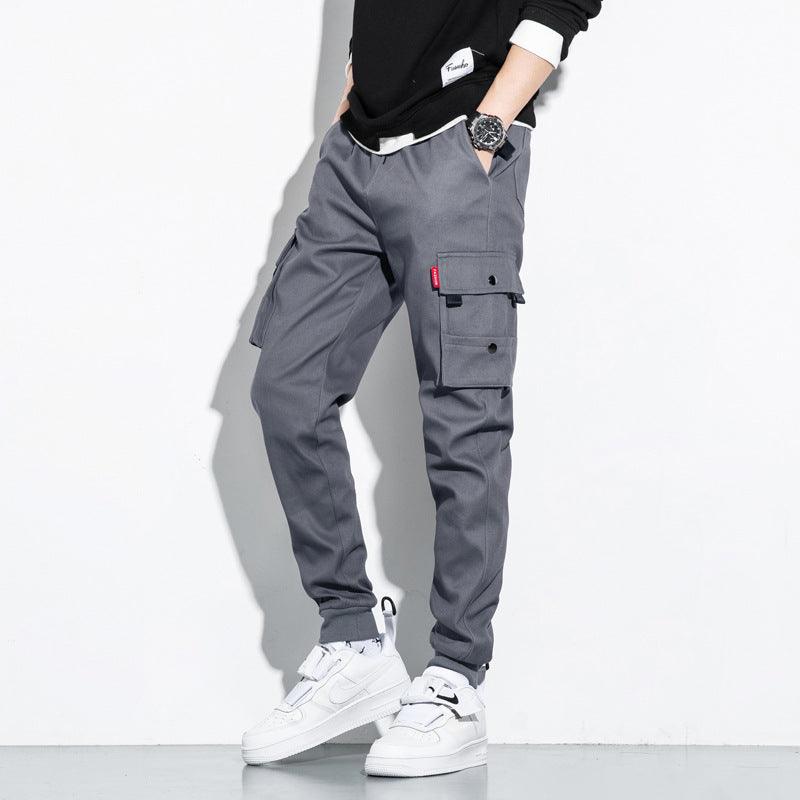 Grey cotton cargo trousers with front flap pockets and side zipper pocket