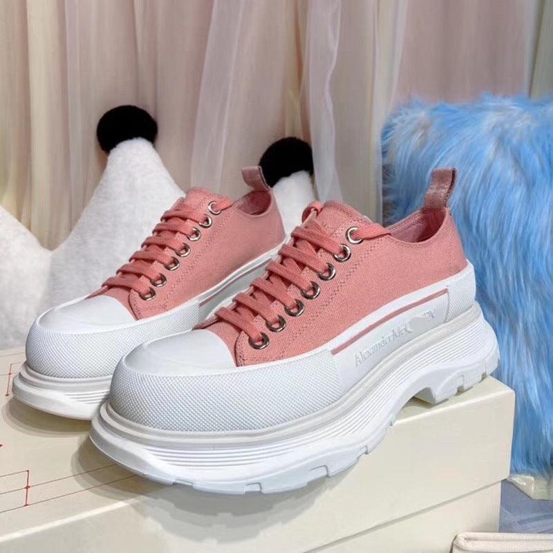 Pink low-top canvas sneakers with thick white sole and lace-up front