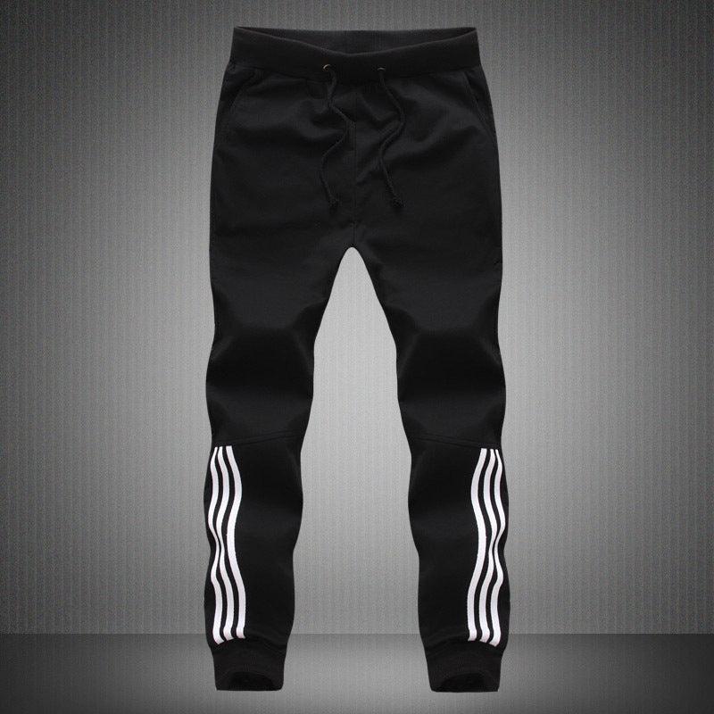 Men's black cuffed jogger pants with white triple stripe on each leg