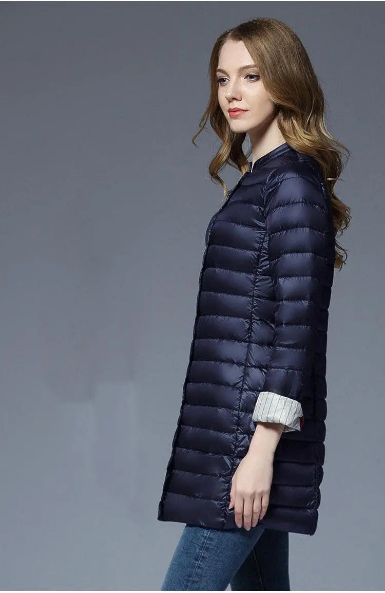 Women's long puffer down jacket in navy, zip front, stand collar, quilted rows.