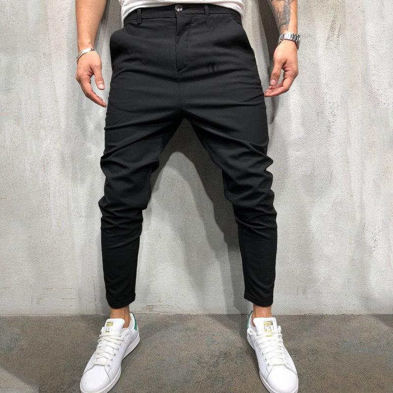 Black slim casual pants with button closure, tapered ankle cuffs, and slash pockets
