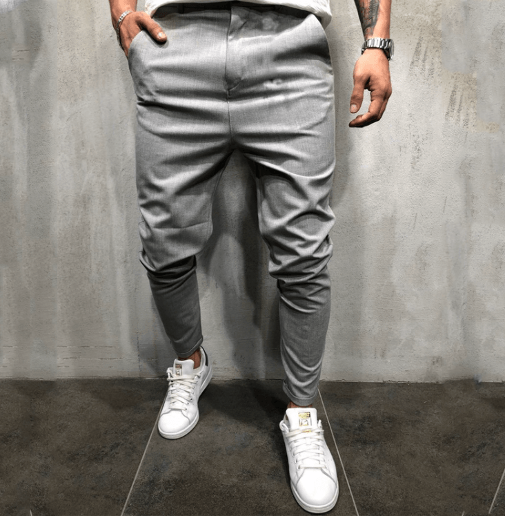 Grey slim-fit casual pants with button waist, tapered cuff hems, and front pockets