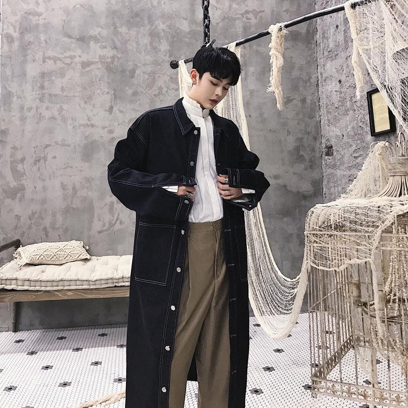 Black denim trench coat with button front, chest pockets, and wide collar.