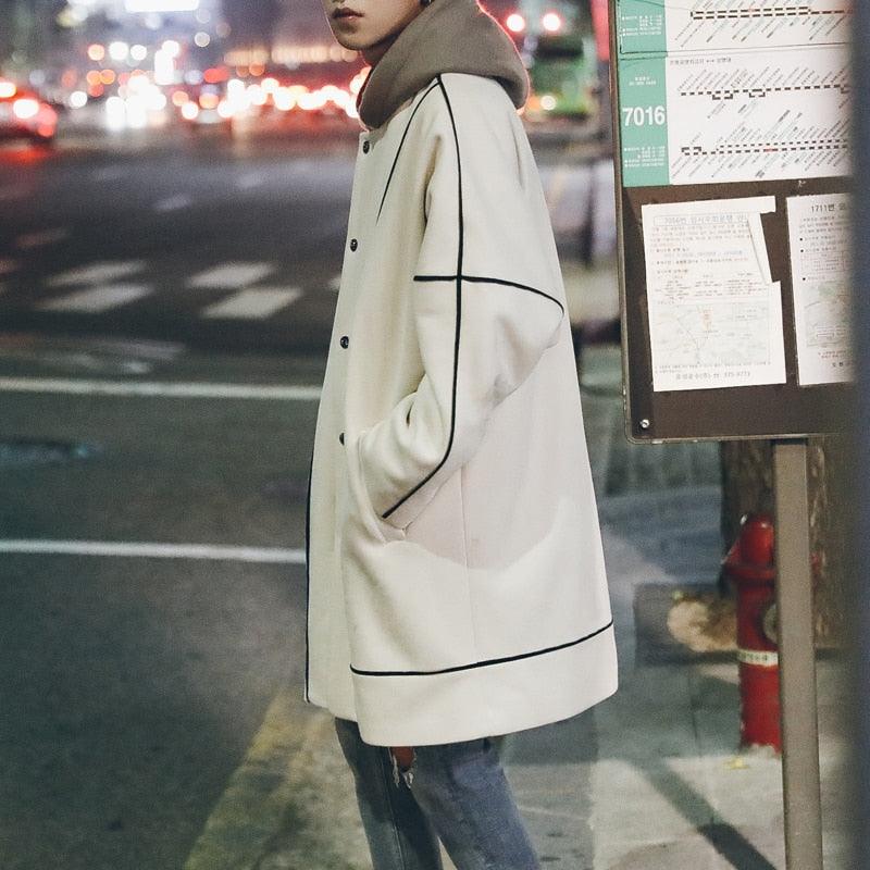 Loose-fit trench coat in creamy white with black contrast piping and button front