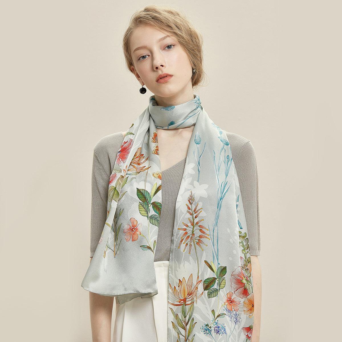 Silk scarf with pale blue background and colorful botanical butterfly-style print, long ends