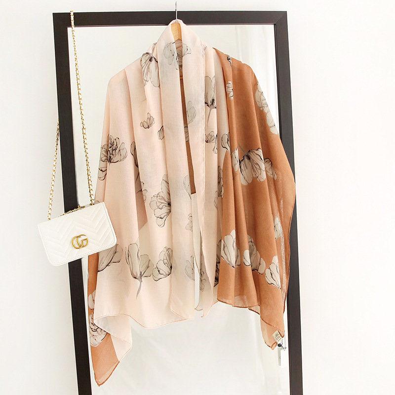 Silk scarf with floral print in warm tan and cream, flowing drape
