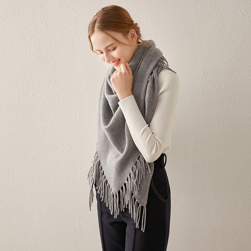 Grey cashmere shawl with long fringe tassels, draped over shoulders