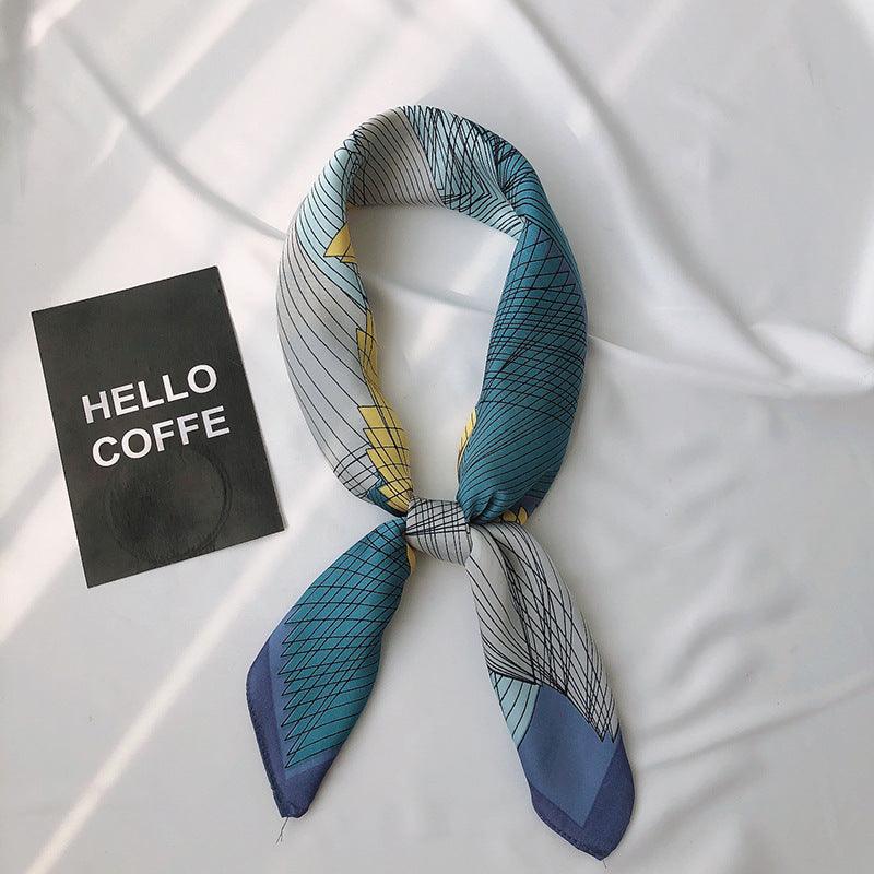 Printed scarf with teal, blue, and white grid lines, tied bow with angled ends