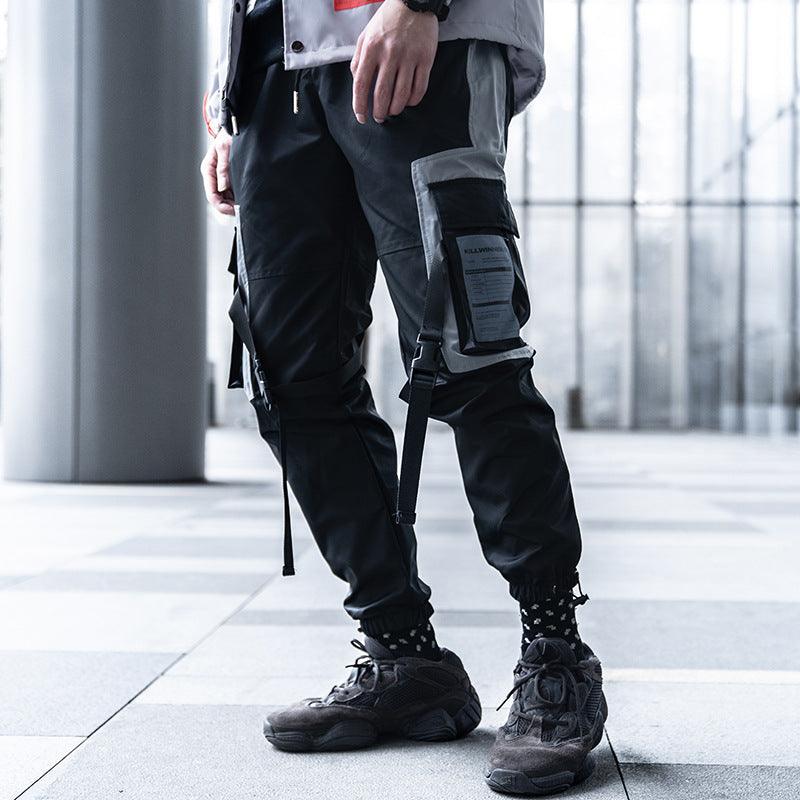 Men's black cargo-style trousers with side strap pockets and tapered jogger cuffs