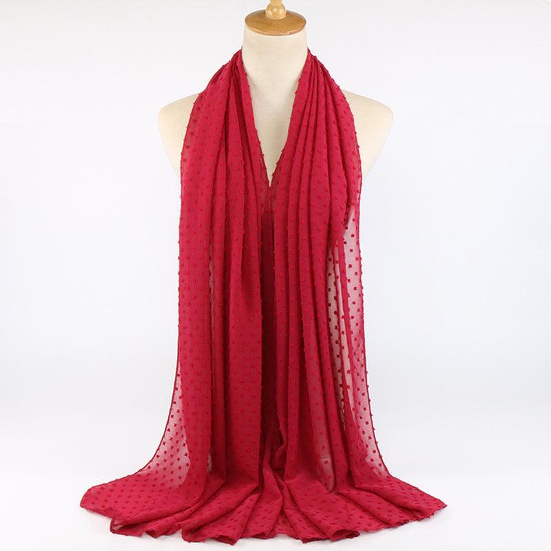 Chiffon folk ball scarf in red with tiny dotted print, loosely draped around neck