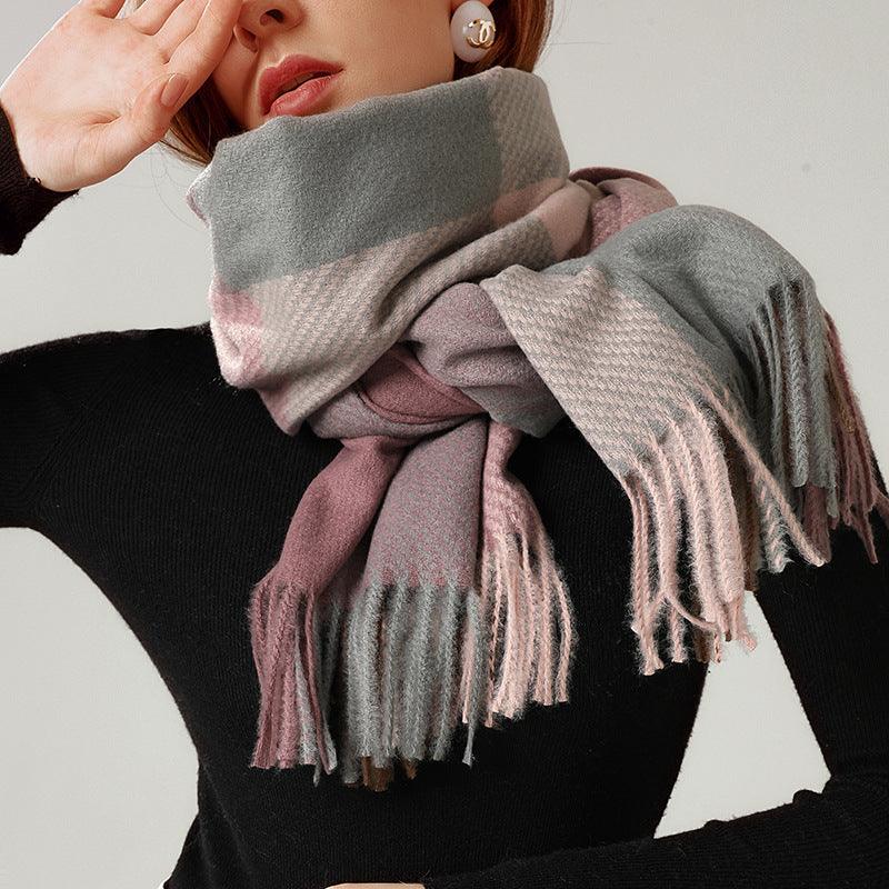Fringed plaid scarf wrapped on model’s neck, showing gray, mauve, and pink blocks