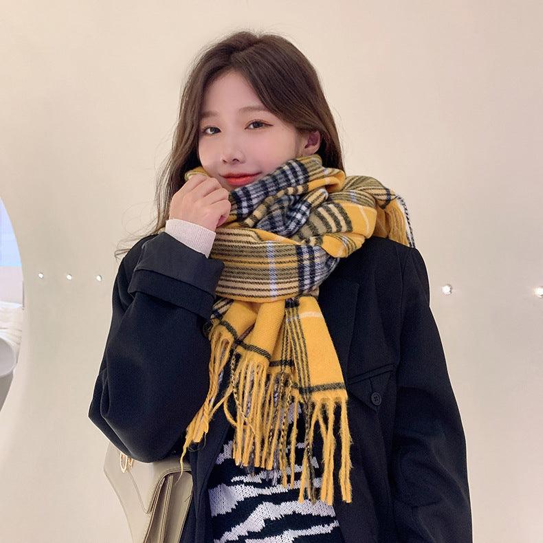 Thick long shawl scarf in yellow and black plaid with fringed ends, worn