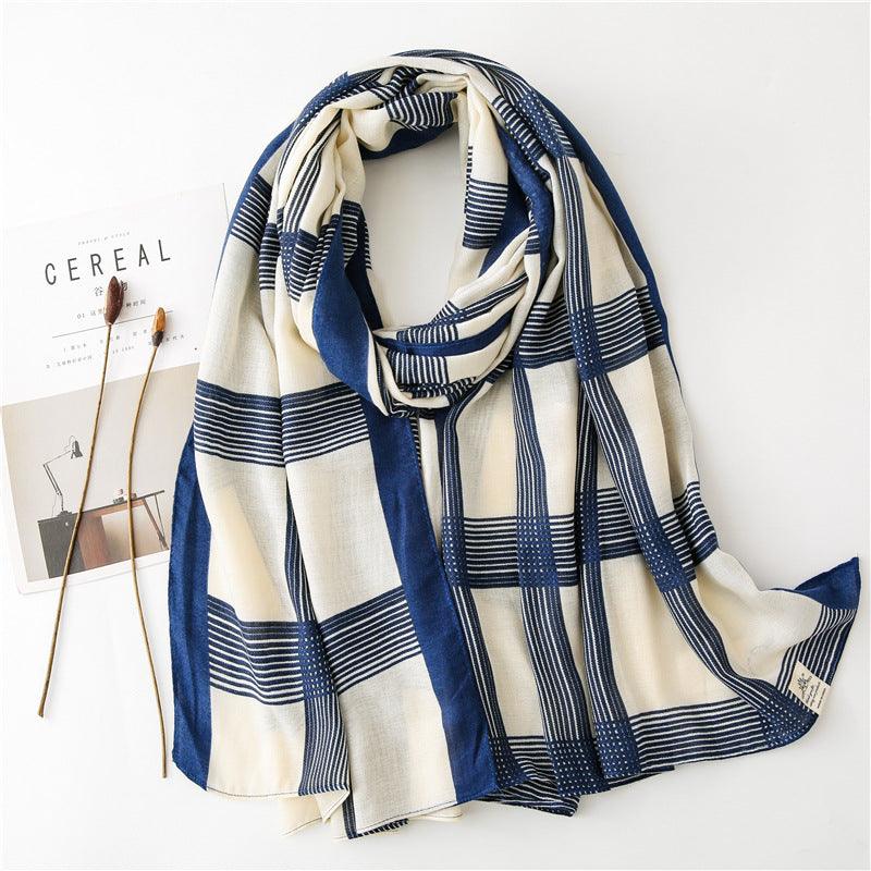 Silk scarf with blue and cream striped pattern, draped with fringed ends