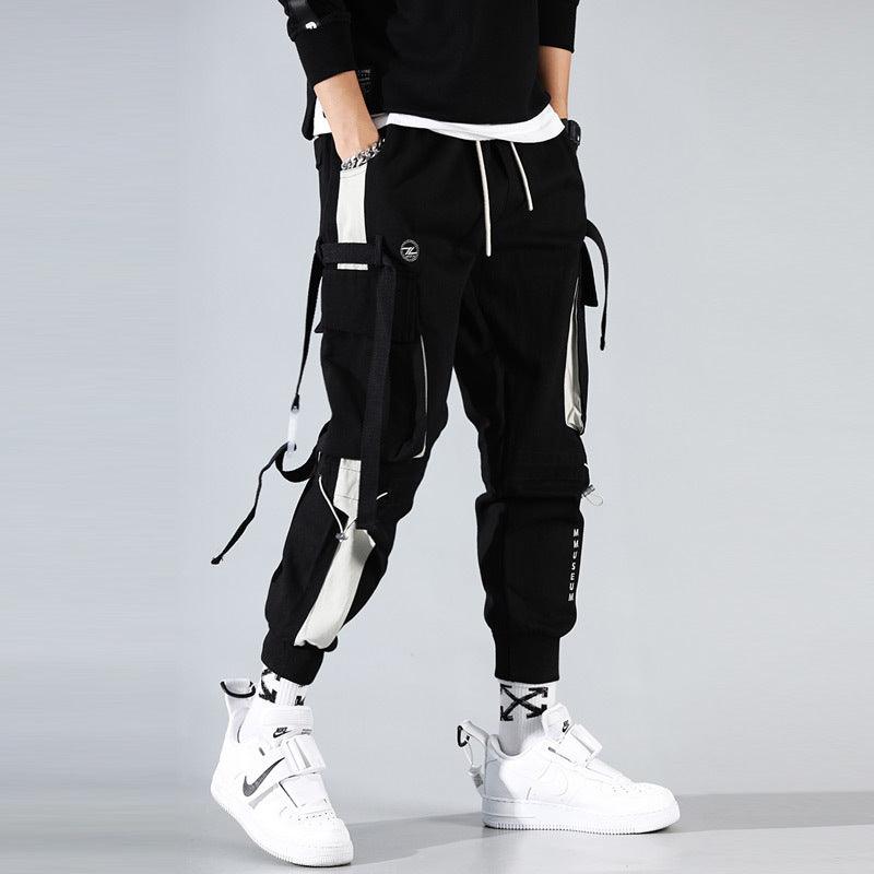 Black harem beam pants with drawstring tie, cargo pockets, and dangling straps