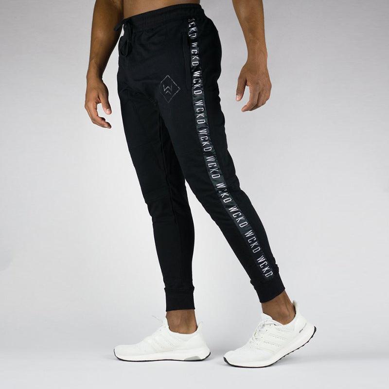 Black slim sports joggers with side logo tape and elastic cuffs, full view