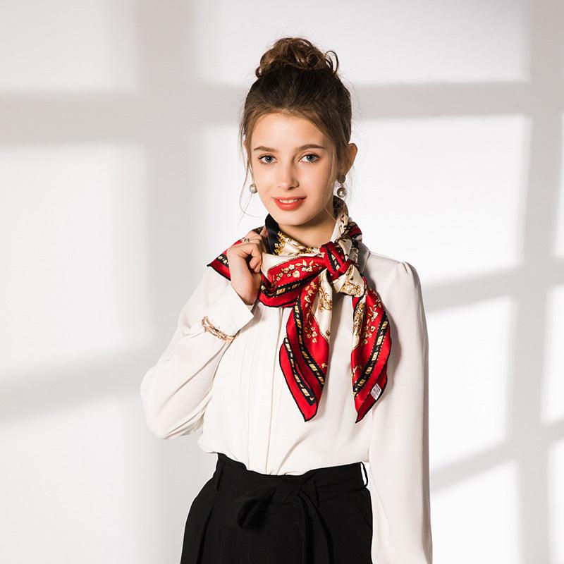 Red and black silk square scarf with ornate print and border, worn around neck