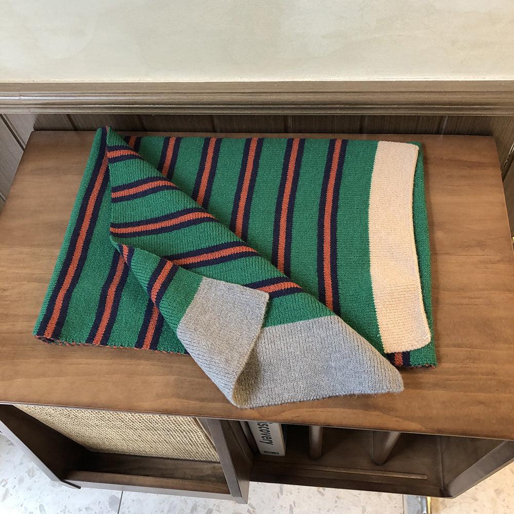 Knitted wool scarf folded; green and dark stripe pattern with cream border