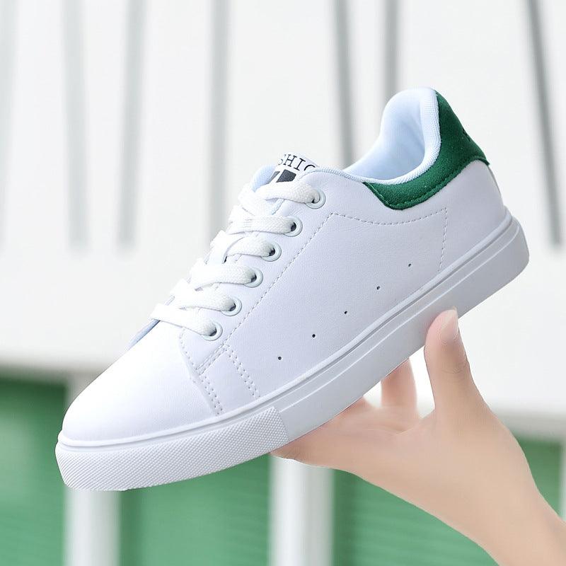 Women’s white low-top sneakers with green heel collar and lace-up front
