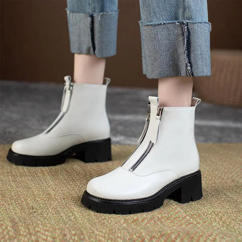 White leather ankle boots with side zipper, silver hardware, and chunky black sole