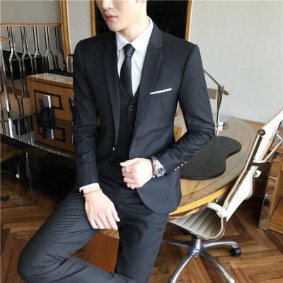 Men's black suit with notch lapels, white shirt, and striped tie