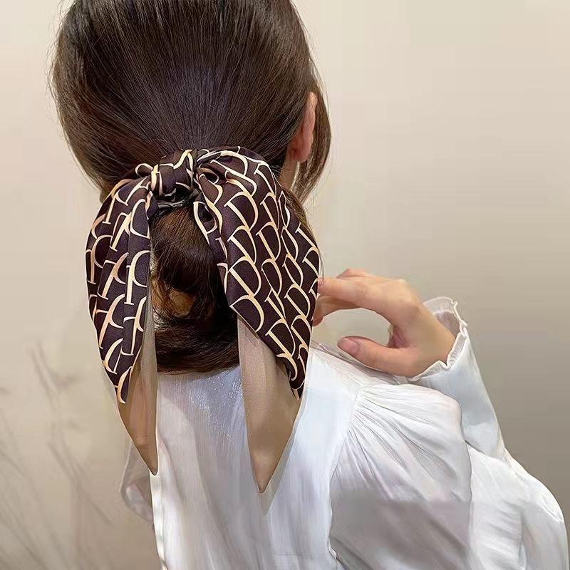 Satin hair headband with tied bow, dark brown scarf with cream motif and beige tie ends