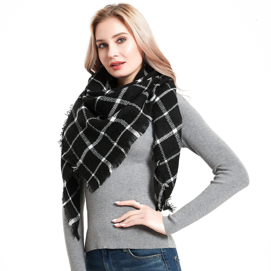 Plaid square scarf in dark tones with white grid pattern and fringed edges.