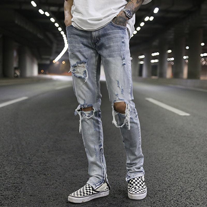 Light blue ripped zipper jeans with distressed patches and frayed knees
