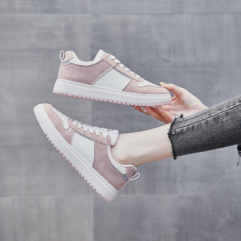 Pink and white low-top lace-up sneakers with padded collar and white rubber sole