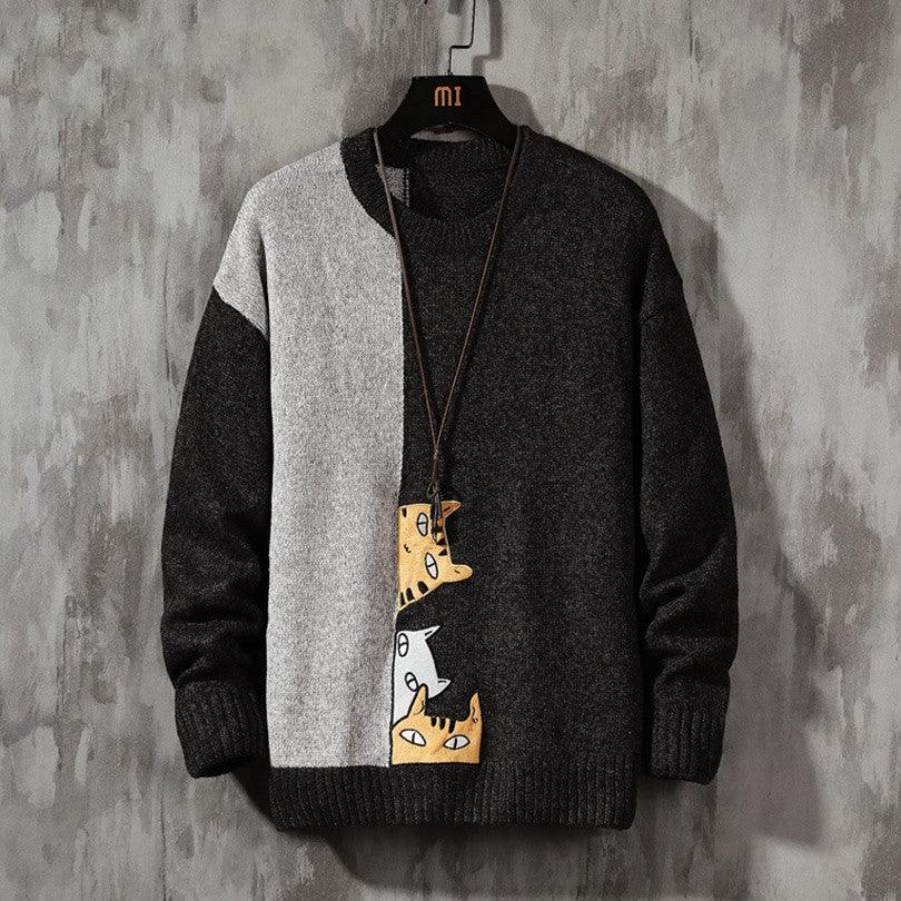 Men's thick knit sweater with black and light panels and cartoon chest graphic, crew neck