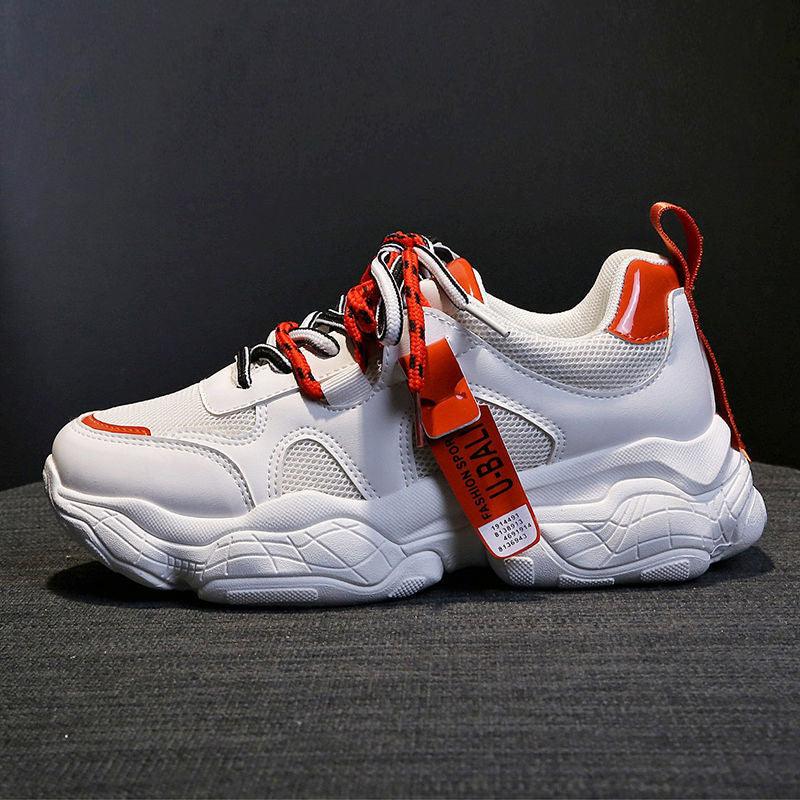 White casual sport sneakers with orange/red lace details, padded collar, chunky sole